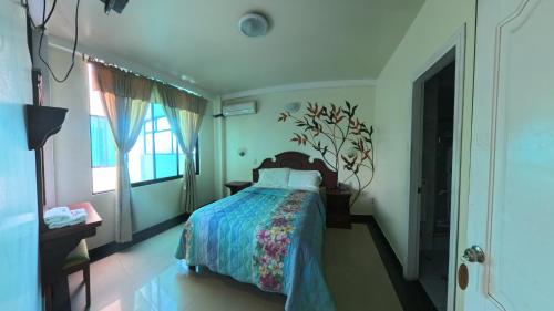 a bedroom with a bed and a window at Hotel Delfin Rosado in Puyo