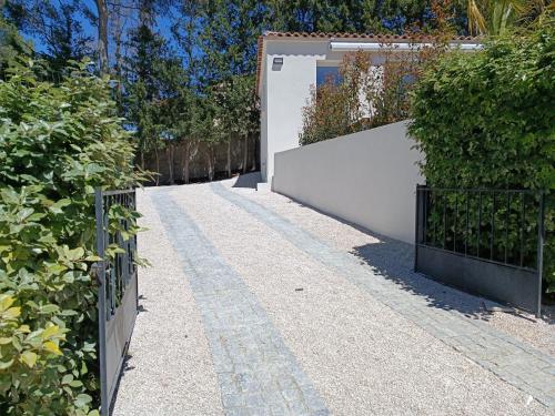 a garden with a gate and a fence at Maison T2 avec jacuzzi in Ensuès-la-Redonne