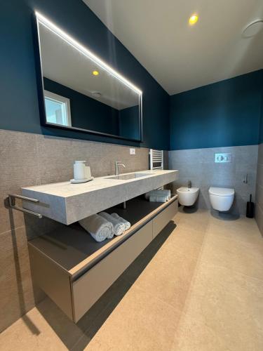 a bathroom with a sink and a toilet and a mirror at Suite Apartments Prestige in Bellaria-Igea Marina