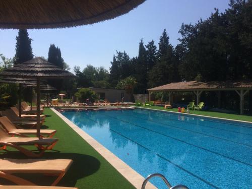 una piscina con tumbonas y sombrilla en La Vallée De Taradeau, en Taradeau