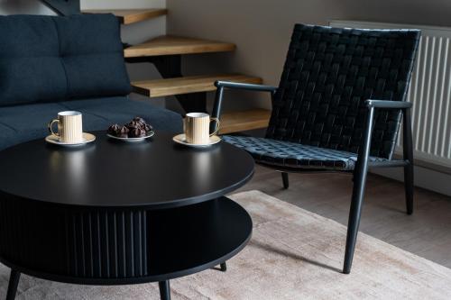 Una mesa de centro negra y sillas en una sala de estar. en Indigo Apartments Loft, en Białystok