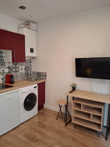 une cuisine avec une machine à laver et une table dans l'établissement Appartement 1 chambre, à Nice
