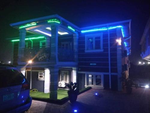 una casa con luces azules y verdes. en DEL HOTEL and SUITES, en Ibafo