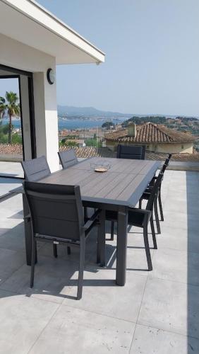une table et des chaises en bois assises sur une terrasse dans l'établissement Sea view and perfect location, à Sanary-sur-Mer
