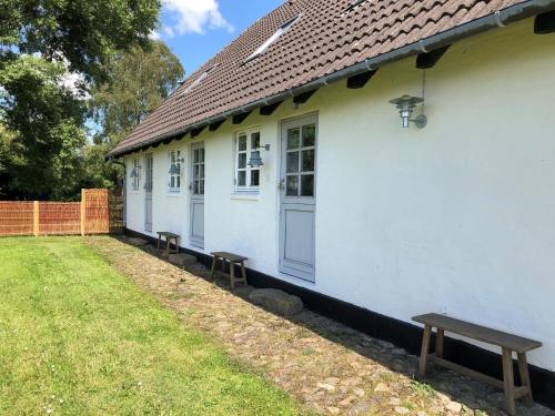 a white house with a bench in front of it at Birkelygaard B&B in Millinge
