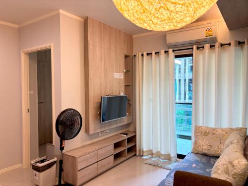 a living room with a couch and a television at LPN Cha-am Beachfront Wifi 10 meters to beach 1BR ติดทะเล in Cha Am
