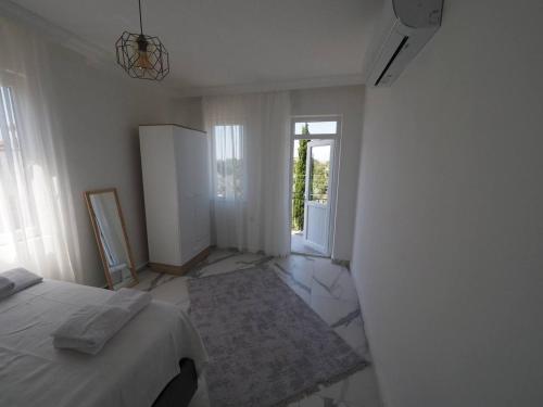 a white room with a bed and a refrigerator at MEY Apart in Kaş