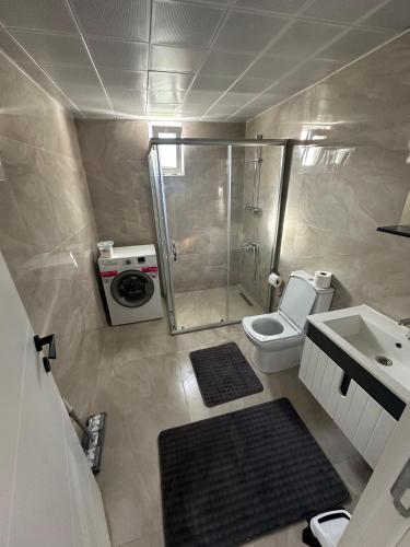 a bathroom with a shower and a toilet and a sink at MEY Apart in Kaş