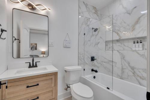 a bathroom with a toilet and a sink and a mirror at Sleeps 24-spacious Suites Near Fq W Pool in New Orleans