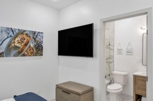 a bathroom with a toilet and a tv on the wall at Sleeps 24-spacious Suites Near Fq W Pool in New Orleans