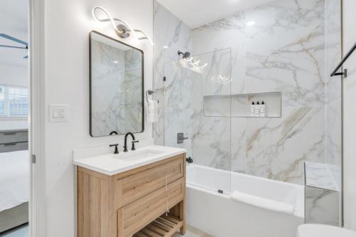 a white bathroom with a sink and a shower at Sleeps 24-spacious Suites Near Fq W Pool in New Orleans