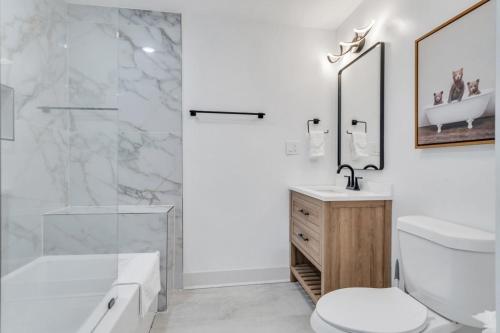 a bathroom with a shower and a toilet and a sink at Sleeps 24-spacious Suites Near Fq W Pool in New Orleans