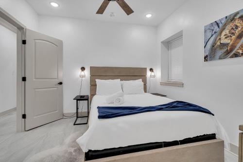 a white bedroom with a large bed and a door at Sleeps 24-spacious Suites Near Fq W Pool in New Orleans