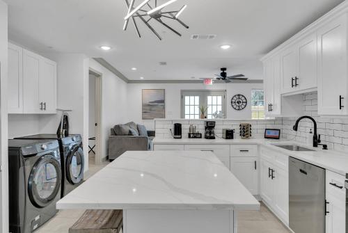 a white kitchen with a washer and dryer at Sleeps 24-spacious Suites Near Fq W Pool in New Orleans
