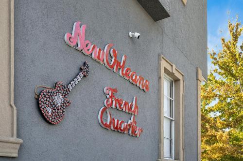a sign on the side of a building with a guitar at Sleeps 24-spacious Suites Near Fq W Pool in New Orleans