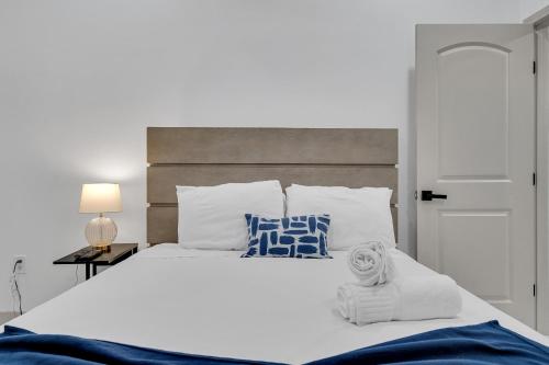 a bedroom with a white bed with blue and white pillows at Sleeps 24-spacious Suites Near Fq W Pool in New Orleans