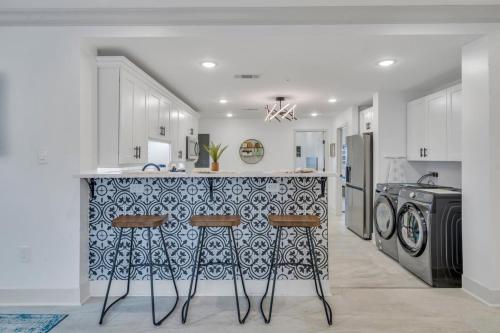 a kitchen with a counter with stools in it at Sleeps 24-spacious Suites Near Fq W Pool in New Orleans