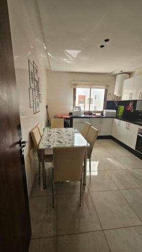 a kitchen and dining room with a table and chairs at Bright and Cosy appartment in Oulad Yakoub