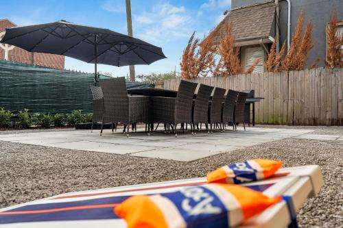 a table and chairs with an umbrella in a backyard at Sleeps 24-spacious Suites Near Fq W Pool in New Orleans