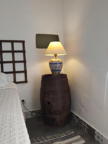 a lamp sitting on top of a barrel in a bedroom at Pé na Terra Quintal in Reguengos de Monsaraz