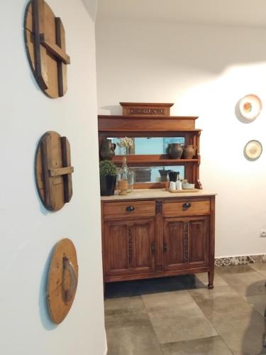 a bathroom with a wooden cabinet and clocks on the wall at Pé na Terra Quintal in Reguengos de Monsaraz