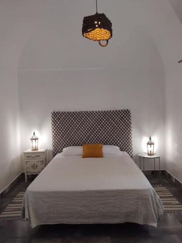 a bedroom with a large white bed and a chandelier at Pé na Terra Quintal in Reguengos de Monsaraz
