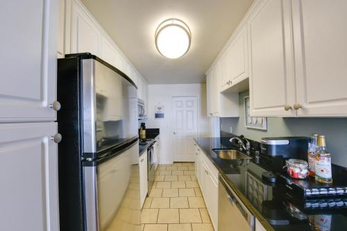 a kitchen with white cabinets and a black refrigerator at Nautical 2 Bedroom with Beautiful Ocean Views in Los Angeles