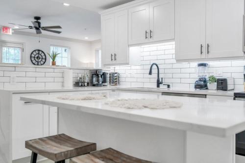 a white kitchen with white cabinets and a sink at Sleeps 24-spacious Suites Near Fq W Pool in New Orleans