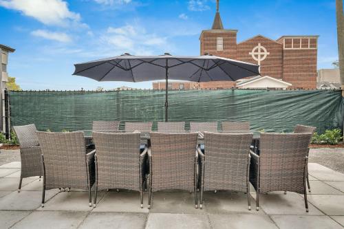 a table with chairs and an umbrella on a patio at Sleeps 24-spacious Suites Near Fq W Pool in New Orleans