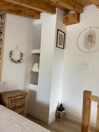 a bedroom with white walls and wooden beams at Posada La Fontana in Santillana del Mar