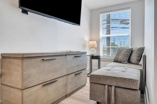 a living room with a dresser and a chair and a tv at Sleeps 24-spacious Suites Near Fq W Pool in New Orleans