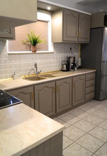 a kitchen with white cabinets and a counter top at IKARUS apartment with courtyard & pool in Chania in Stérnai