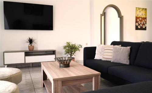 a living room with a couch and a table at IKARUS apartment with courtyard & pool in Chania in Stérnai