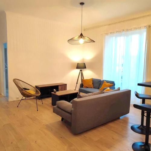 un salon avec un canapé et une chaise dans l'établissement Joli T2 proche Arènes et gare, à Nîmes
