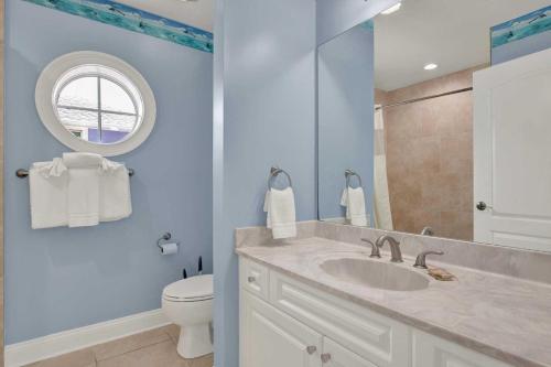a bathroom with a sink and a toilet and a mirror at Oceanview on Tybee 202-1 in Tybee Island
