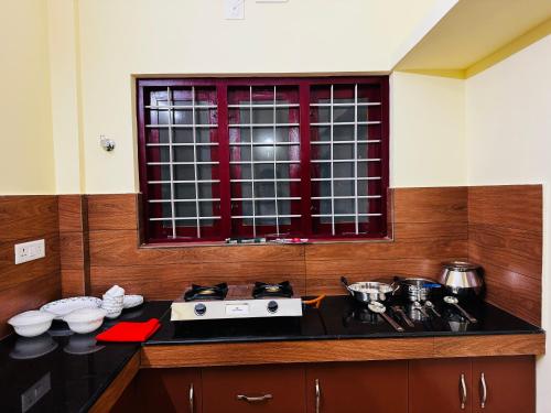 a kitchen with a counter with a stove and a window at AL-Kabeer Cybernest apartments Infosys in Trivandrum