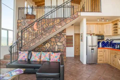 a living room with a couch and a staircase at En'kanto Valle de Guadalupe in San Marcos