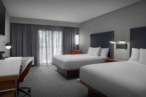 a hotel room with two beds and a desk at Courtyard Spokane Downtown at the Convention Center in Spokane