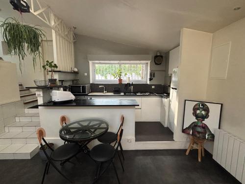 une cuisine avec un comptoir, une table et des chaises dans l'établissement Atypical house near Paris & Disney, à Champigny-sur-Marne