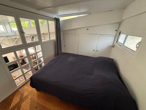 une petite chambre avec un lit et une fenêtre dans l'établissement Atypical house near Paris & Disney, à Champigny-sur-Marne