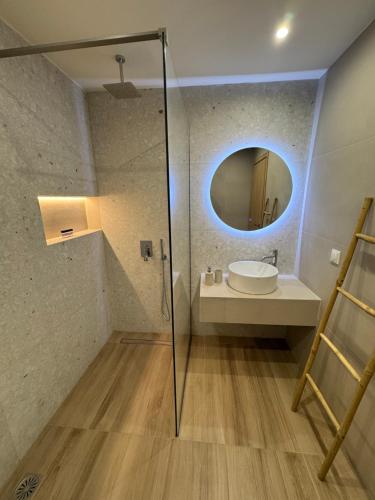 a bathroom with a sink and a mirror at Artemis Apartments in Diakopto
