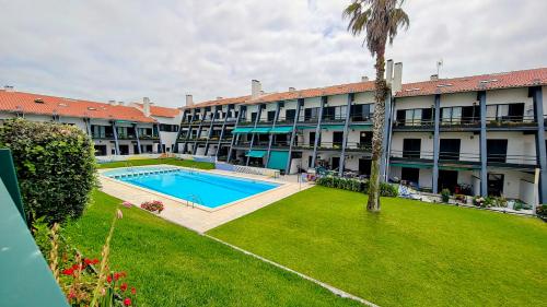 an apartment building with a swimming pool and a yard at Pedra do Ouro Yoga Retreat apartment in Pataias