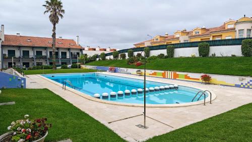 a large swimming pool in a yard with buildings at Pedra do Ouro Yoga Retreat apartment in Pataias