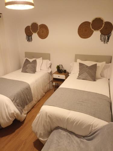 a bedroom with two beds and two mirrors on the wall at Apartamento Brañas Home1 in Cambados