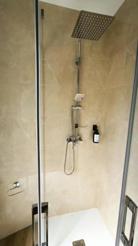 a shower with a glass door in a bathroom at Torreón El Guindal - Sierra de Gredos in Mijares