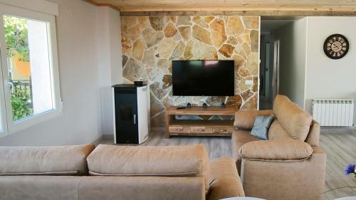 a living room with two couches and a flat screen tv at Torreón El Guindal - Sierra de Gredos in Mijares