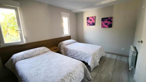 a room with two beds and a window at Torreón El Guindal - Sierra de Gredos in Mijares