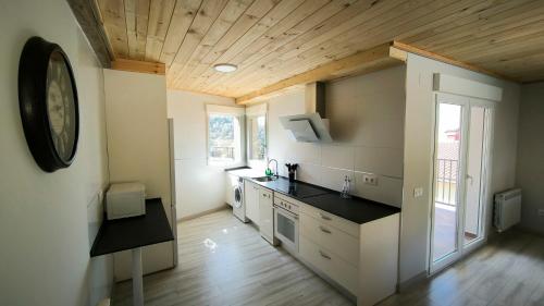 a kitchen with a counter and a clock on the wall at Torreón El Guindal - Sierra de Gredos in Mijares