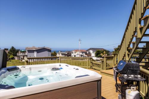 a jacuzzi tub on the deck of a house at Beachcomber Monthly Only in Cambria