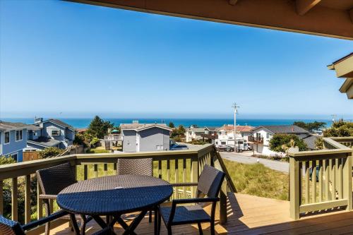 a balcony with a table and chairs and a view of the ocean at Beachcomber Monthly Only in Cambria